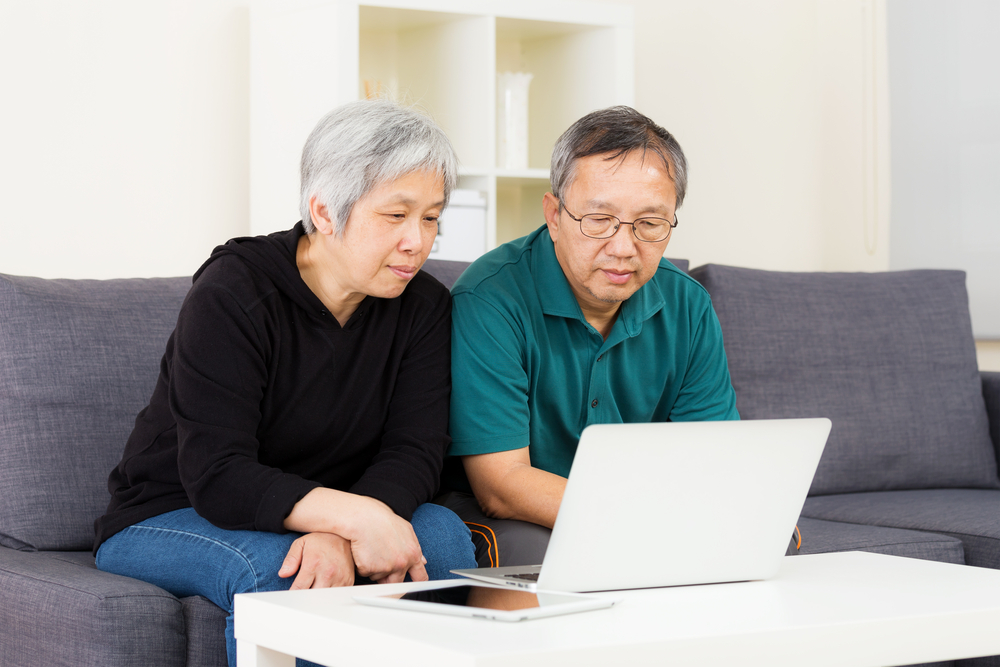 Asian old couple using laptop property management software